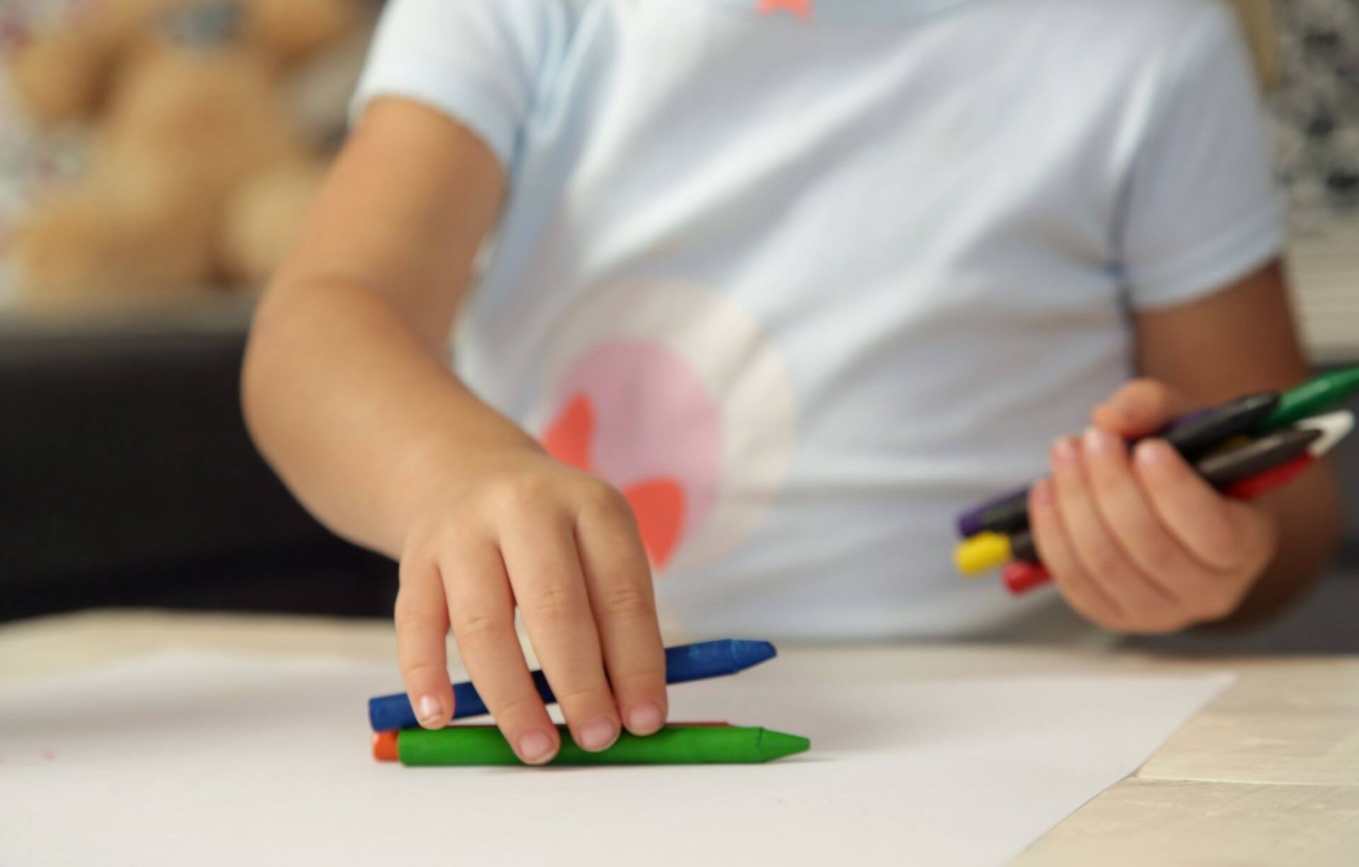 A photo of a childs hands playing with Crayons