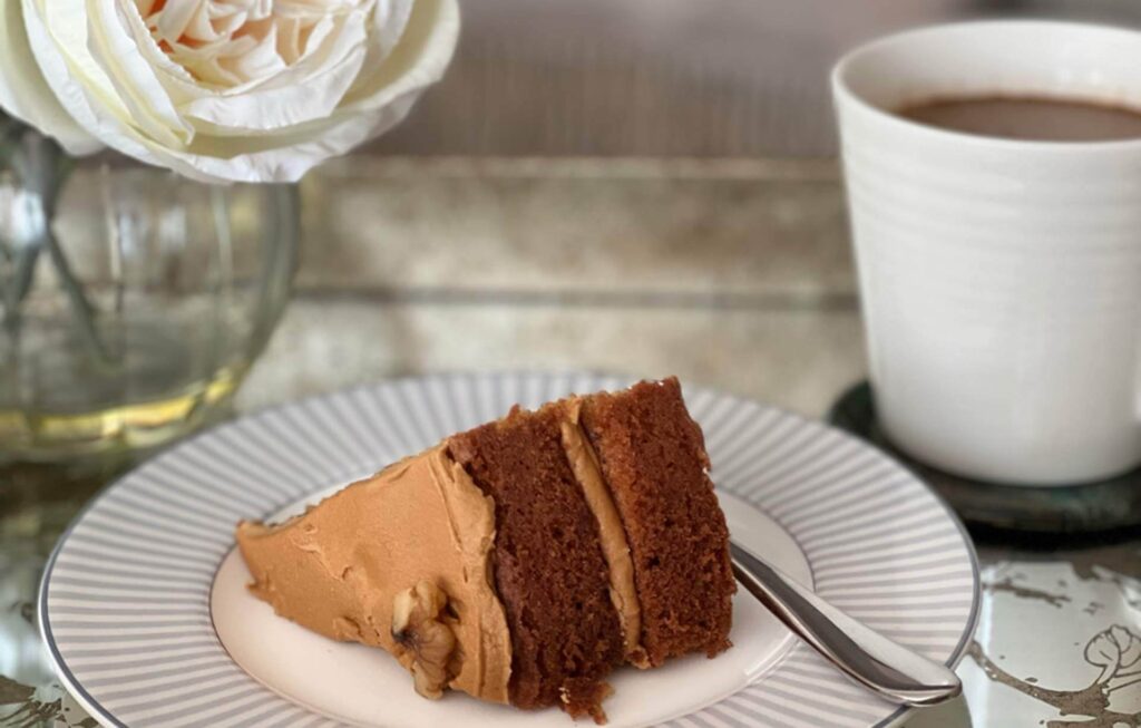 A photo of a slice of coffee and walnut cake